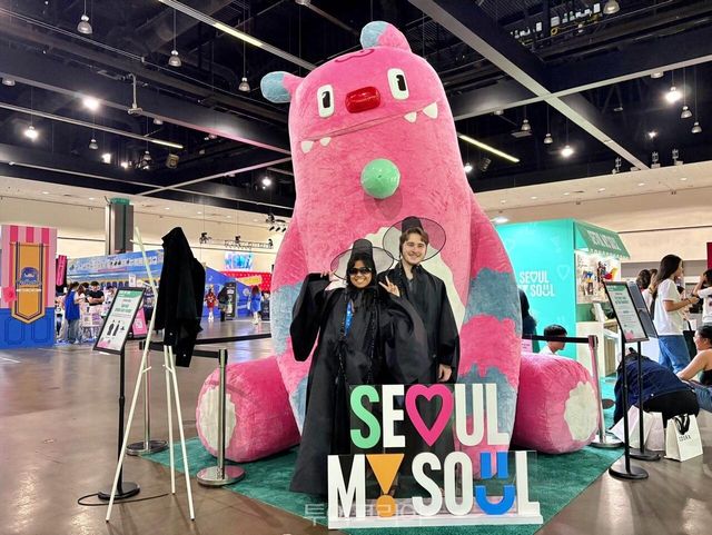 KCON LA 서울관광 홍보부스 방문객이 영화 케이팝 데몬 헌터스에서 나온 갓과 도포를 착용하고 해치 포토부스에서 사진을 찍고 있다/사진-서울관광재단