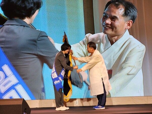 박규환 민주당 당 대변인 겸 경북도당 직무대행이 임미애 의원에게 도당기를 전달하고 있다./사진-민주당 경북도당