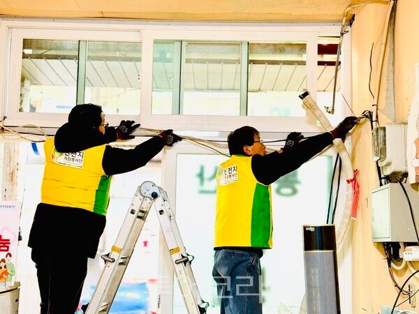 시장 내 오래된 전선을 교체하는 마산지부 봉사자들. /사진-신천지자원봉사단 마산지부