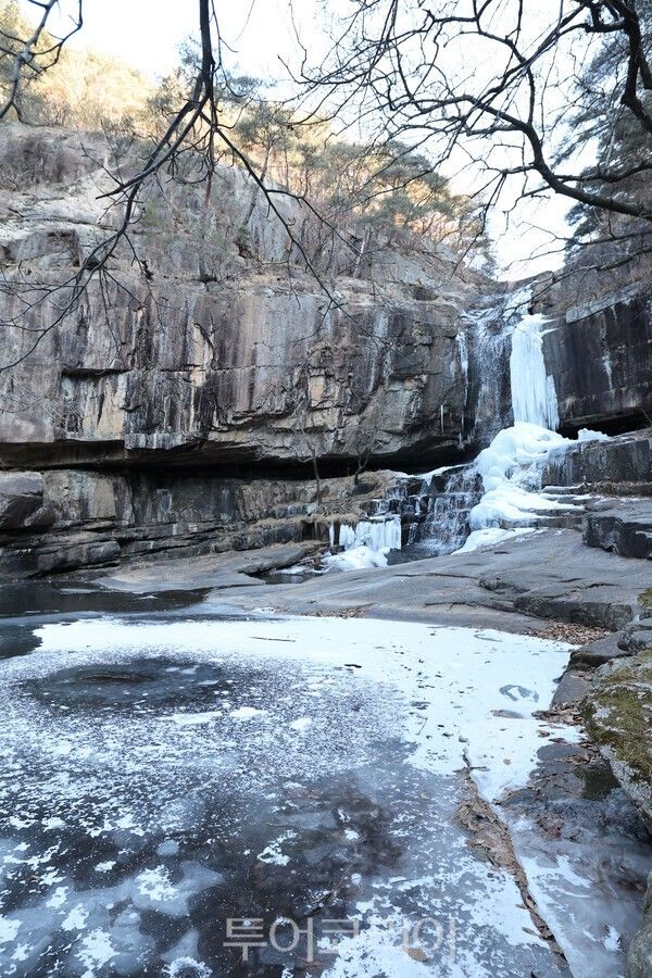얼음이 내려앉은 계곡과 폭포가 어우러져 고요한 겨울 분위기를 전하고 있다. /사진-괴산군