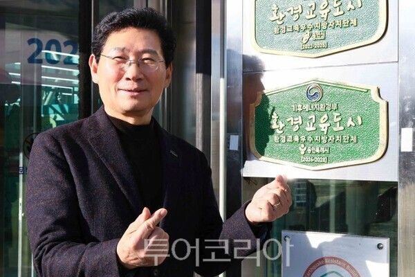 이상일 시장이 환경교육도시 현판 앞에서 포즈를 취하고 있다/투어코리아뉴스 정명달 기자