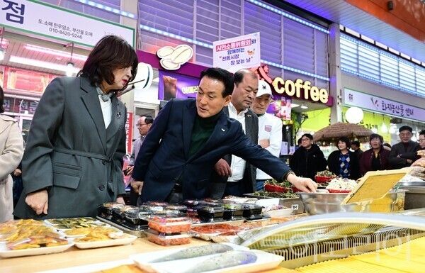 ▲전통시장에서 장보기에 나선 백성현(왼쪽 두 번째) 논산시장이 좌판에 진열된 상품들을 살펴보고 있다. /사진-논산시