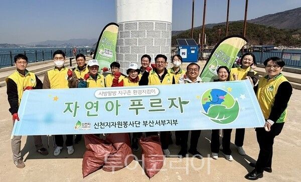 지난 23일 가덕도 천성항에서 '자연아 푸르자' 캠페인을 진행하는 가운데 봉사자들이 기념촬영을 하고 있다. /사진-신천지자원봉사단 부산서부지부
