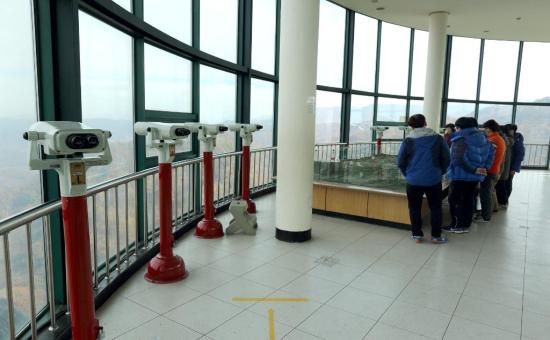 승리전망대에서 쌍안경을 통해 북쪽을 바라보는 관광객들 /사진 =철원군