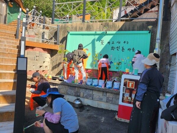 태백시 장성동 그림동아리 ‘그림그리는사람들’이 지난 9일 재능기부활동으로 장성중앙시장 골목 벽면에 화사한 꽃과 친근한 동물 벽화를 그리고 있다./사진=태백시