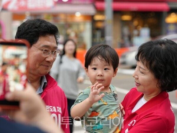 이상일 용인특례시장 후보가 현장 유세에서 아기를 바라보고 있다/투어코리아뉴스 정명달 기자