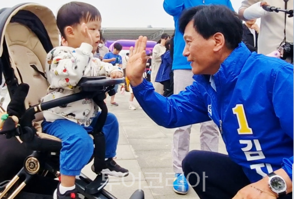 김진규 후보가 행사 참여 어린이와 하이파이브를 하고 있다. (사진=검단구출입연합기자단)