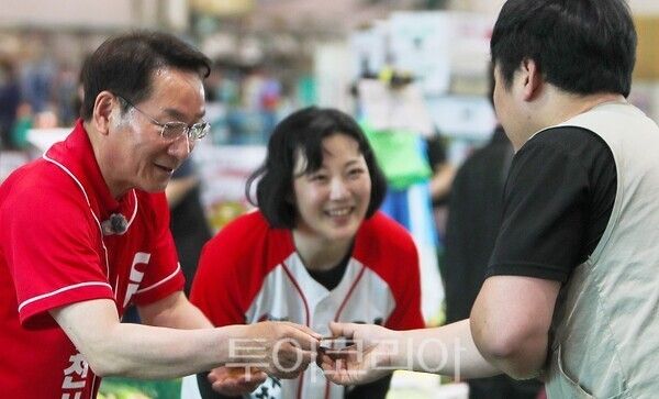 30일 유정복 인천시장 후보가 부평구 삼산농산물시장을 방문해 상인에게 명함을 전달하며 인사를 나누고 있다.