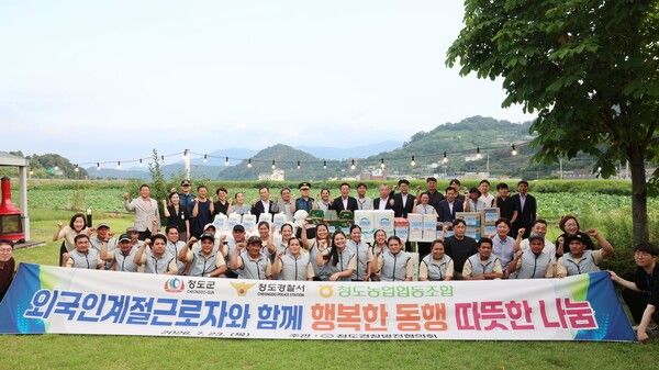 박현권 청도군수와 유관기관 관계자들이 외국인 계절근로자들을 위문하고 기념촬영을 하고 있다./사진-청도군