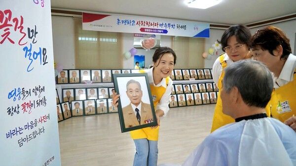 지난 3월 신천지자원봉사단 제천지부 봉사자들이 보훈 어르신에게 장수 사진 촬영 후 완성된 사진을 보여주며 이야기를 나누고 있다. (사진제공=신천지자원봉사단)