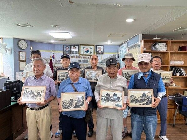 지난 23일 신천지자원봉사단 부산서부지부가 월남전참전자회 사하구지회를 방문하여 '맥박으로 그린 AI수묵화'를 전달한 가운데 참전용사들과 기념촬영을 하고 있다. (사진제공=신천지자원봉사단)