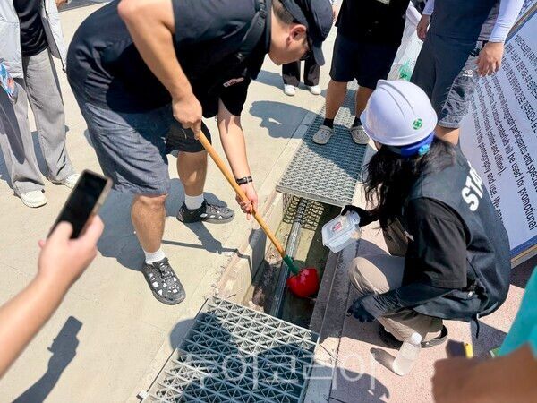 ▲충남 보령시 보령머드축제 체험장에서 배출된 머드와 물이 하수처리장을 거치지 않은 채 우수관을 따라 바다로 향한 사실이 확인된 가운데 오염여부를 확인하기 위해 머드와 오염수 시료를 채취하고 있다. /사진-보령시프레스협회
