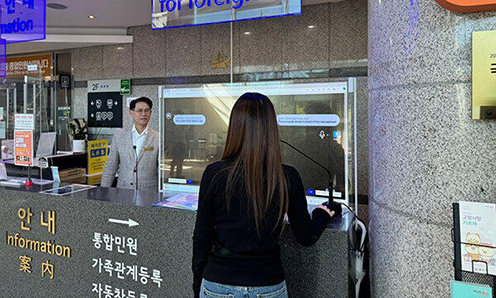 ▲ 서울 용산구가 구청 업무를 어려워하는 이들을 돕고자 배치한 민원 상담관이 다국어 동시통역 서비스를 활용해 민원 응대를 하고 있다. 사진제공 = 용산구