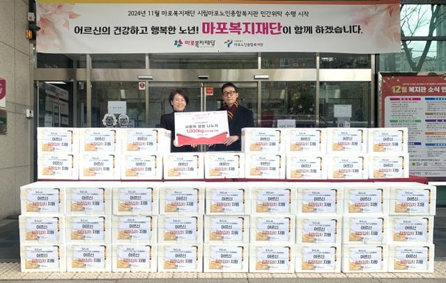 이효창 개발원 대외협력홍보부장(오른쪽)이 정영숙 마포노인종합복지관 관장과 사랑의 김장김치 나눔 행사에서 기념촬영을 하는 모습./사진제공=한국지역정보개발원