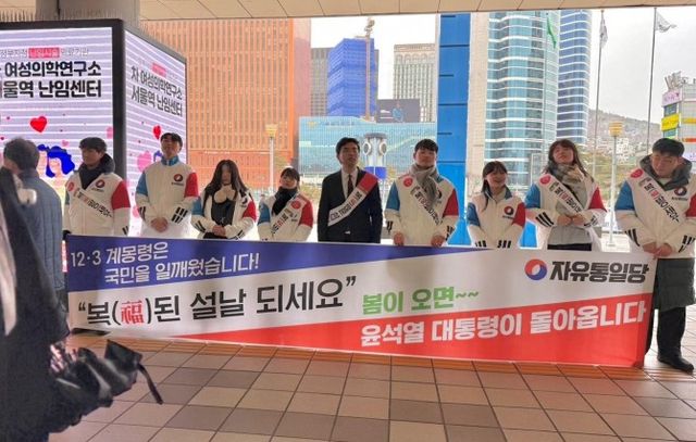 자유통일당 청년 홍보위원들이 27일 설 연휴를 맞아 서울역에서 귀성객들에게 명절 인사를 전하고 있다. ⓒ 자유통일당