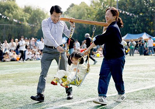 ▲ 서강석(왼쪽) 서울 송파구청장이 지난해 열린 ‘송파 어린이집 대잔치’에서 참여 가족들과 함께하고 있다. 사진제공 = 송파구
