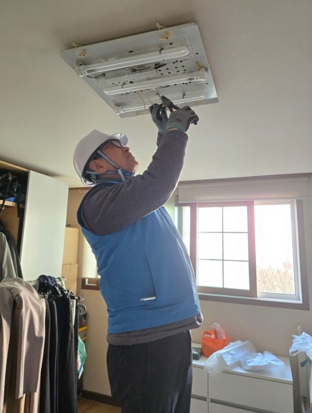 송파구 직원이 봉사활동을 통해 취약계층에 고효율 LED 조명 교체를 진행하는 모습./사진제공=송파구