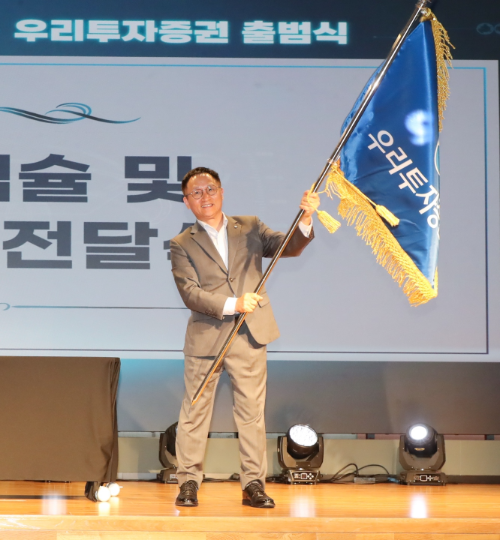 ▲ 1일 남기천 우리투자증권 대표이사가 여의도 TP타워 소재 본사에서 열린 출범식에서 회사기를 흔들고 있다. / 사진제공= 우리투자증권(2024.08.01)