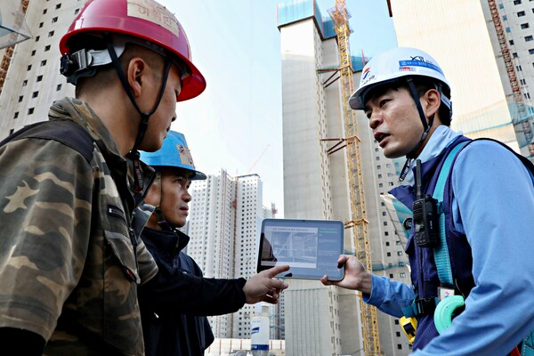 GS건설 아파트 건설현장에서 ‘자이 보이스’를 활용해 외국인 근로자에게 작업 내용을 설명하는 모습./사진제공=GS건설