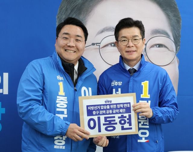 이동현 중구청장 예비후보(왼쪽)가 정원오 서울시장 예비후보에게 중구권역 공동 공약 정책 연대를 위한 제안서를 전달하고 기념 촬영을 하는 모습./사진제공=이동현 예비후보 캠프