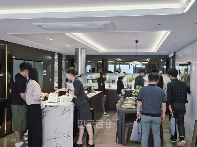전용 113㎡A 유니트 내부 주방에서 방문객들이 배치와 구성에 대해 확인하고 있다./사진=조범형 기자