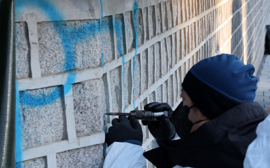 문화재청 작업자들이 17일 오전 서울 종로구 경복궁 서편 담장에 칠해진 낙서 제거 작업을 하고 있다 (2023.12.17) / 출처 - 뉴시스