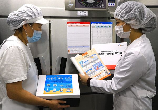 지난 28일, 서울시 마포구 아현실버복지관 급식 조리실에서 CJ프레시웨이 식품안전 담당자(오른쪽)가 조리사(왼쪽)에게 위생안전 솔루션을 제공하고 있다.