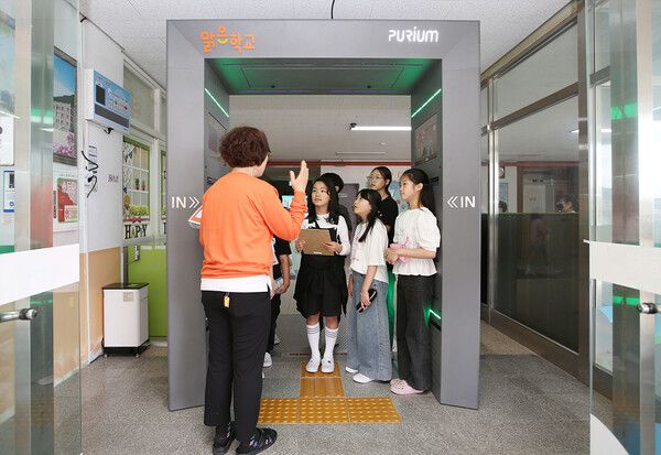 정읍 남초등학교 선생님과 학생들이 '맑은학교 만들기'를 통해 조성된 에어샤워 사용설명을 듣고 있다.&nbsp;