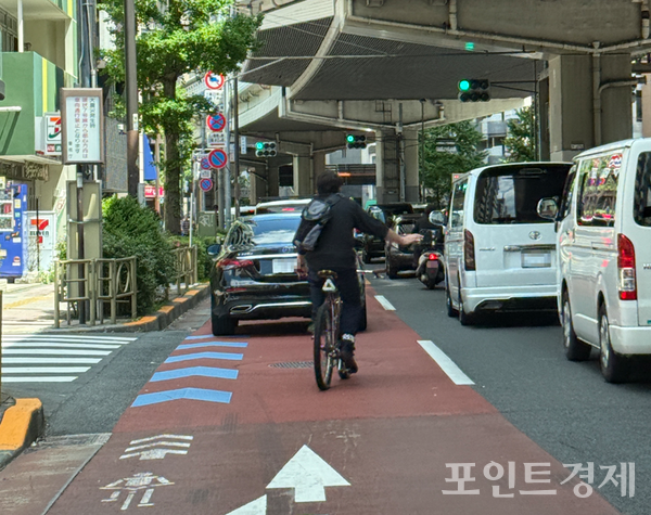 일본의 자전거 내비마크(自転車ナビマーク)를 달리는 출근길 자전거 이용자ⓒ포인트경제 박진우