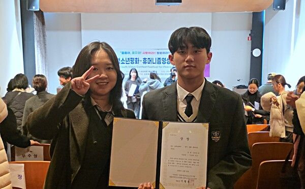 영풍 석포제련소가 후원한 ‘민낯의 미소’가 제 16회 국제청소년평화·휴머니즘영상공모제에서 우수상을 수상했다. 2025년 12월 30일 휴영제 시상식에서 민낯의 미소를 연출한 최은영(사진 왼쪽) 학생과 주연배우로 출연한 김준우 학생이 기념사진을 찍는 모습. /영풍 제공