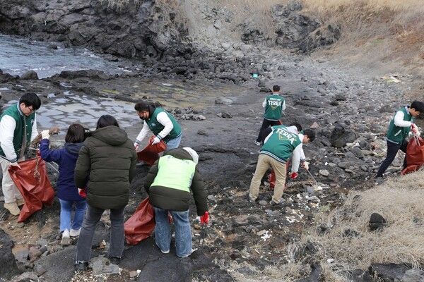 지난&nbsp;14일 제주 닭머르해안에서 하이트진로 제주지점과 아라종합사회복지관 임직원이 해안 정화활동에 참여하는 모습 [사진=하이트진로](포인트경제)