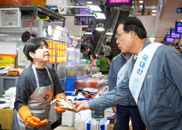 노동진 수협중앙회장(오른쪽)이 지난해 9월 4일 노량진수산시장을 찾아 매주 수요일마다 제철 수산물을 최대 30% 싸게 판매하는 '노량진 수산데이'에 참여한 상인과 얘기를 나누고 있다. /수협중앙회 제공
