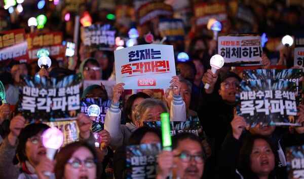 지난&nbsp;24일 서울 종로구 동십자각 앞에서 열린 윤석열 대통령 탄핵 촉구 집회에서 참가자들이 손 피켓을 들고 있다. /사진=뉴시스