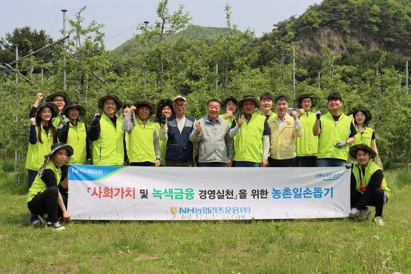 NH농협리츠운용이 지난 13일 경기도 포천시에서 임정수 대표이사(오른쪽에서 여섯 번째)와 임직원 봉사단이 농촌 일손돕기를 하고 기념사진을 촬영하고 있다. [사진=NH농협금융지주](포인트경제)