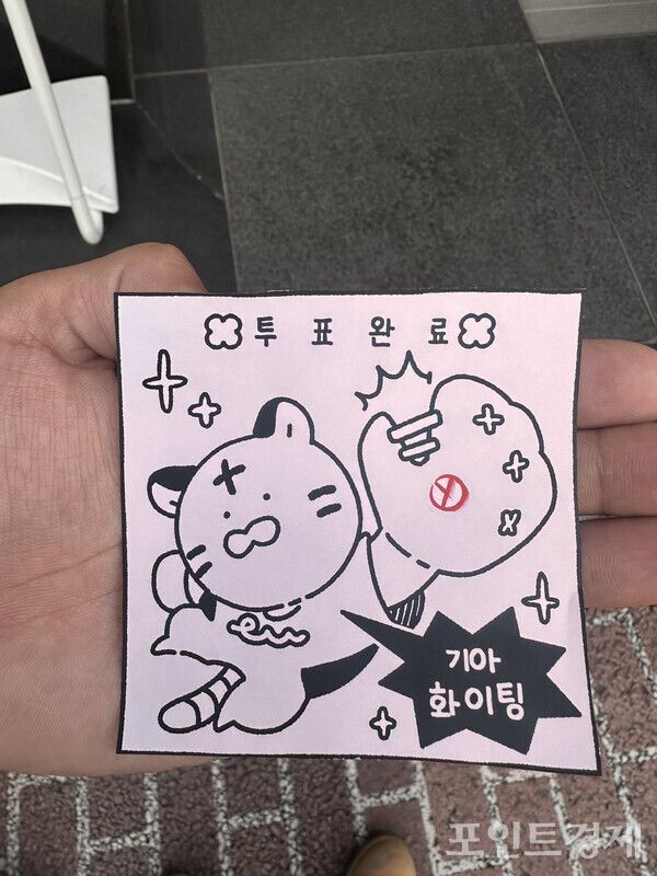 20일 오전 8시 10분께 도쿄 대한민국 영사관 앞에 제21대 대통령선거 재외국민 투표를 마치고 나온 한 유학생이 투표 완료를 기념한 그림을 그려 보여주고 있다. ⓒ포인트경제 박진우 도쿄특파원