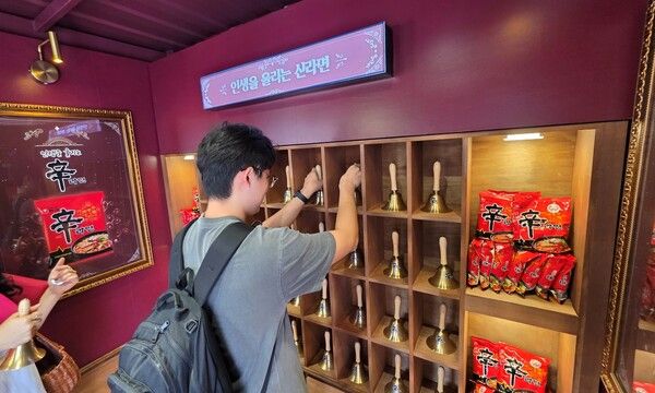 지난 20일 숭실대학교에서 진행한 팝업스토어 현장으로, '인생을 울리는 신라면' 존 앞에서 대학생이 '종 울리기'를 하고 있다. [사진=농심](포인트경제)