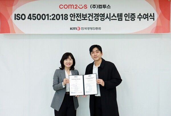 컴투스가 한국경영인증원으로부터 안전보건경영시스템 인증을 받고 관계자들이 기념촬영을 하고 있다. 김진우 컴투스 업무지원실장(사진 우측),&nbsp;황은주&nbsp;KMR&nbsp;대표(사진 좌측)