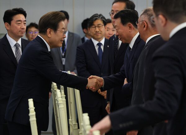 이재명 대통령이 13일 서울 용산 대통령실에서 열린 6경제단체와 기업인 간담회에 입장하며 신동빈 롯데그룹 회장과 악수하고 있다. /사진=뉴시스