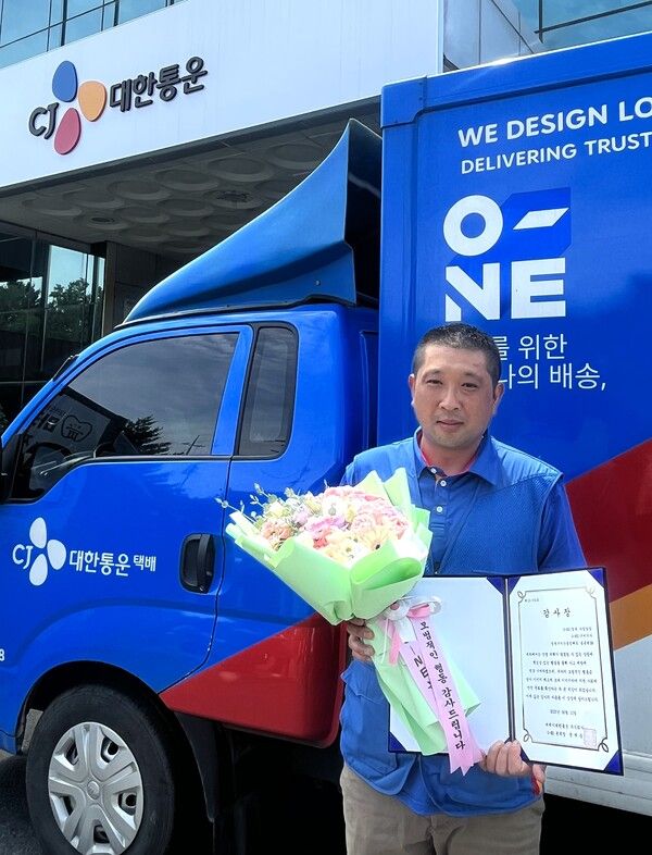 CJ대한통운&nbsp;택배기사 송종현씨가&nbsp;시민 구조에 기여한 공로로 감사장을 받고 기념촬영을 하고 있다. /CJ대한통운 제공
