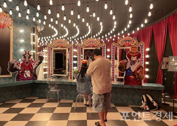 ‘로스트아크’ 단독 미디어아트 전시 ‘빛의 여정’. 방문객이 소품을 사용해서 사진을 찍고 있다. ⓒ포인트경제