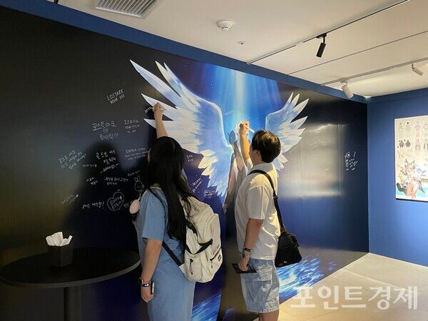 &nbsp;‘로스트아크’ 단독 미디어아트 전시 ‘빛의 여정’. 방문자들이 방명록에 글을 남기고 있다. ⓒ포인트경제