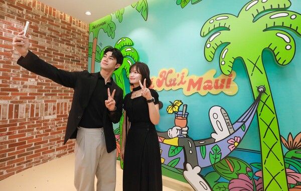 29일 오전 현대백화점 판교점에서 고객들이 글로벌 팝 아티스트 작가 스티븐 해링턴의 하와이 콘셉트 그래픽 앞에서 기념사진을 찍고 있다. /현대백화점 제공