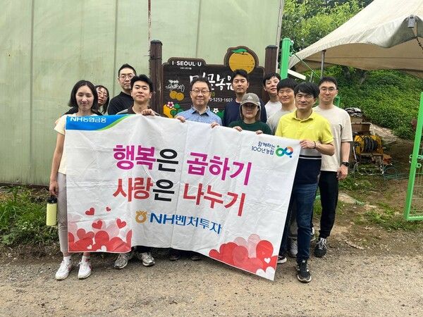 NH벤처투자는 24일, 서울 중랑구 먹골농원에서 농촌일손돕기를 실시했다. 김현진 대표이사(앞줄 왼쪽에서 세 번째)와 임직원들이 기념 촬영을 하고 있다.