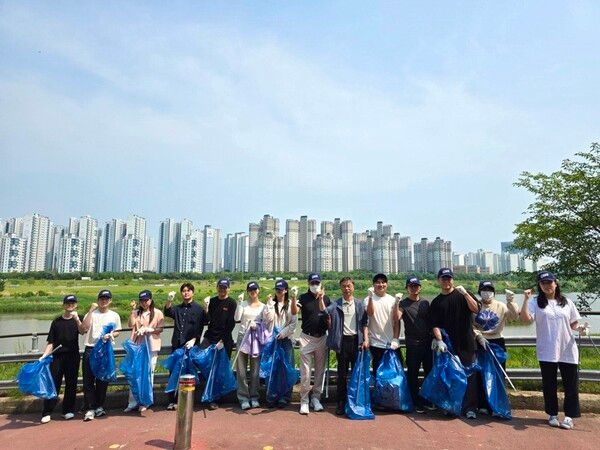 오비맥주 광주공장 직원들이 ‘세계 환경의 날’을 기념해 ‘광주시민의 숲’ 정화 활동을 마치고 기념사진을 찍고 있다. [사진=오비맥주](포인트경제)