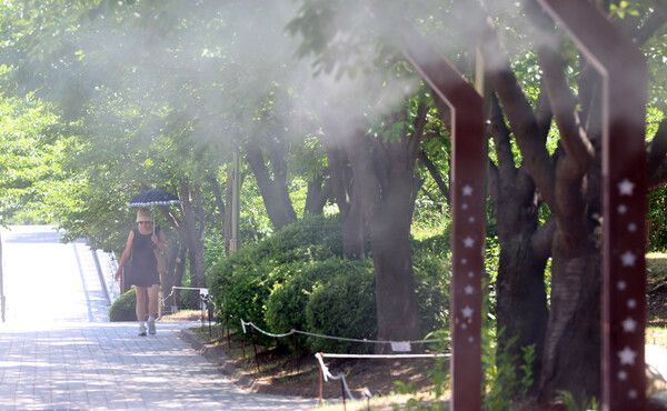 연일 폭염이 이어지는 11일 인천 남동구 중앙공원에서 한 시민이 쿨링포그를 맞으며 걸어가고 있다. /사진=뉴시스