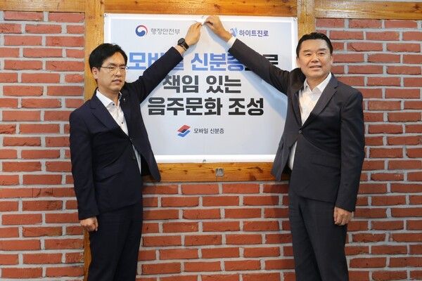 지난&nbsp;14일,&nbsp;하이트진로 김인규 대표(오른쪽)와 행정안전부 김민재 차관(왼쪽)이 행정안전부가 지정한 서울 서초동 하이트진로 본사 인근 착한가격업소를 방문해 모바일 신분증 활용을 권장하는 홍보 포스터를 부착했다. /하이트진로 제공