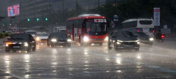 서울에 호우주의보가 내려진 13일 서울 종로구 세종대로에서 전조등을 켠 차량이 주행하고 있다. /사진=뉴시스