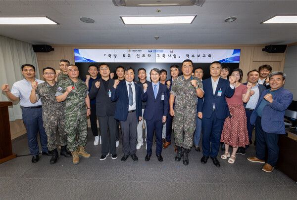 KT Enterprise부문 이행1본부장 이진권 상무(앞줄 왼쪽부터 6번째)와 국방부, 한국지능정보사회진흥원(NIA) 주요 관계자가 ‘국방 5G 인프라 구축’ 사업 착수보고회에서 단체 기념사진을 촬영하는 모습 / KT제공 (포인트경제)