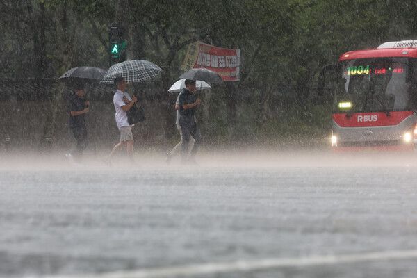 서울지역에 호우경보가 발효된 13일 서울 중구 시청역 인근에서 시민들이 많은 비에 우산을 쓰고 이동하고 있다. /사진=뉴시스