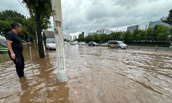 서울을 비롯한 수도권에 호우주의보가 내린 13일 경기 고양시 통일로에서 한 시민이 침수된 도로를 바라보고 있다. /사진=뉴시스